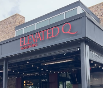 Photo outside of Elevated Q restaurant of their patio and signage