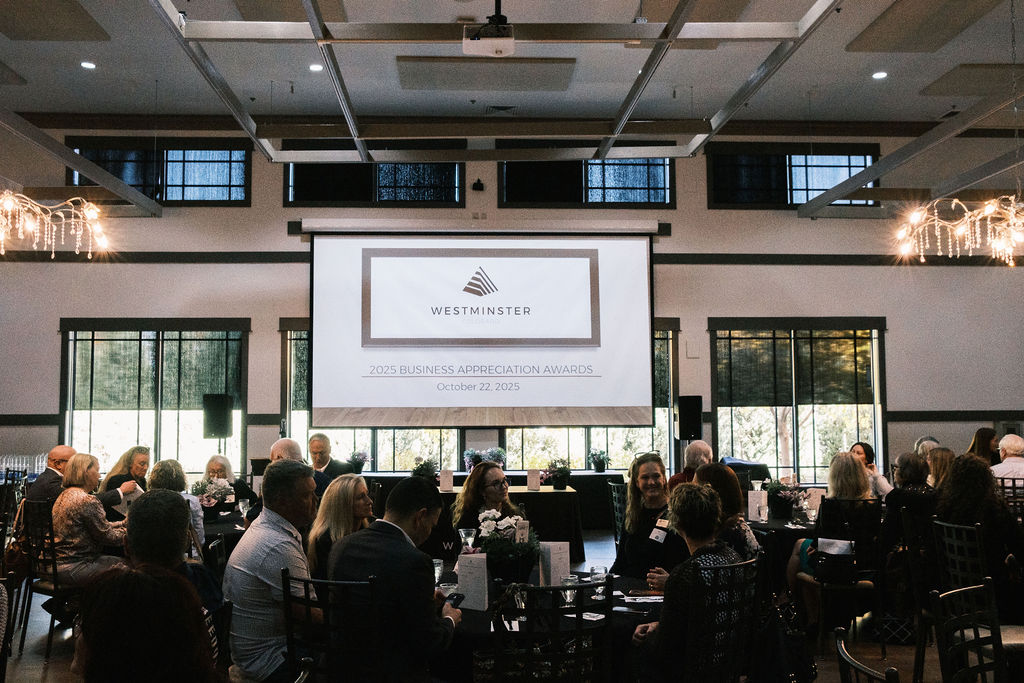 People sitting at tables having lunch in front of a projection screen
