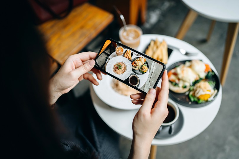 Person taking a photo of food on a plate