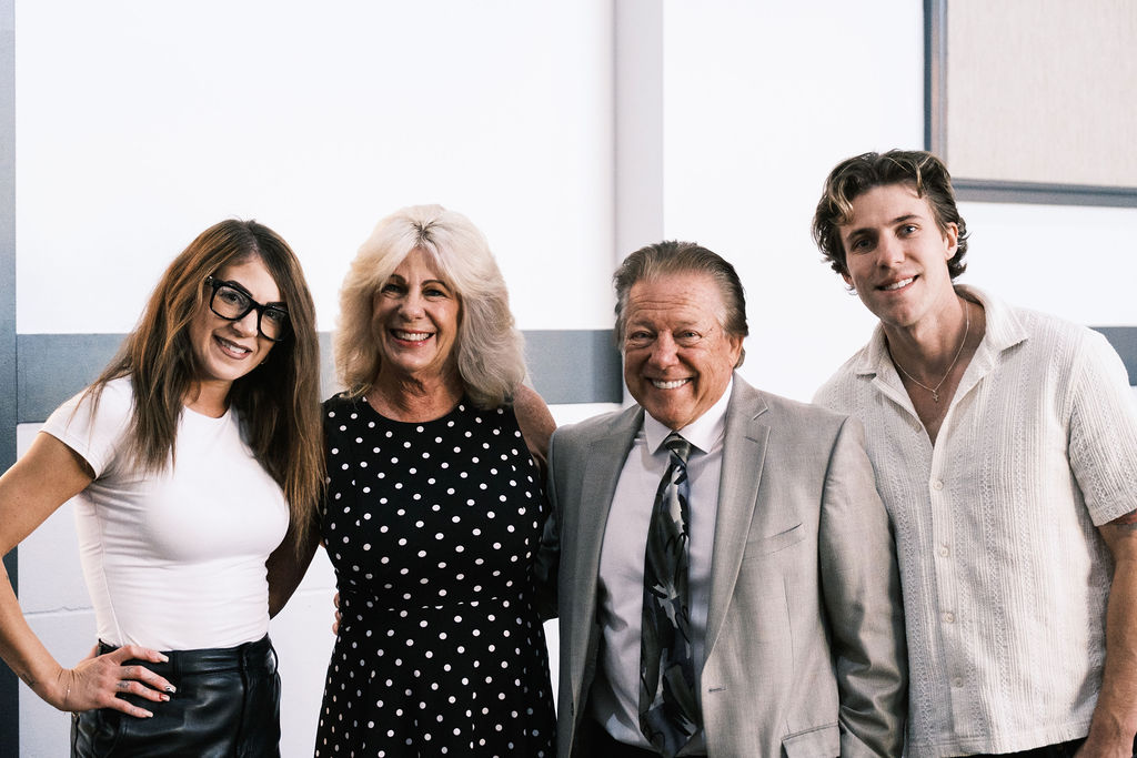 4 people standing together to pose for a photo